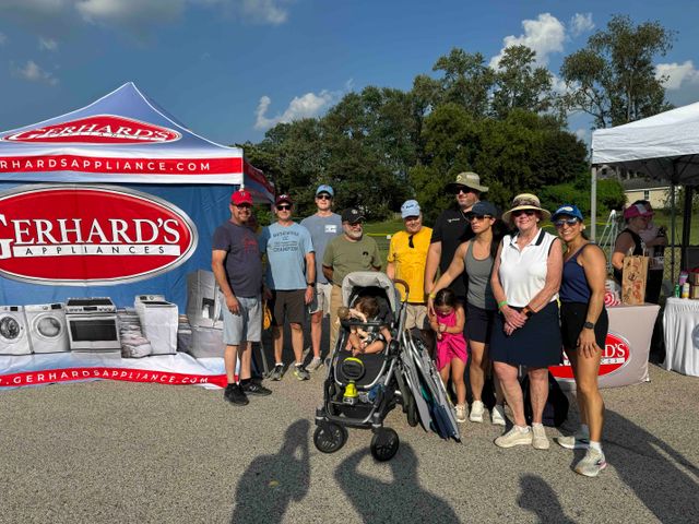 A group of people stands in front of the activities at Gerhard's Summer Slam